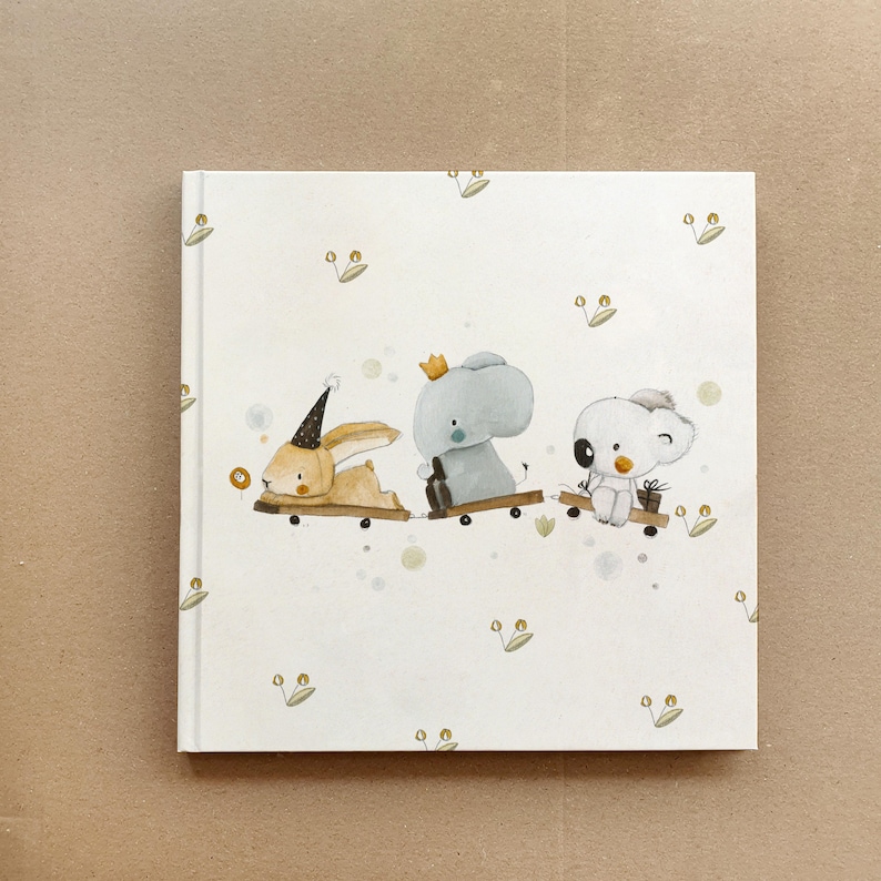 May include: A white book cover with a whimsical illustration of a bunny, an elephant, and a koala riding on toy skateboards. The background is white with a subtle pattern of green leaves.