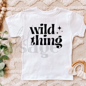 May include: White t-shirt with black text that reads "wild thing" with stars above the word "wild".