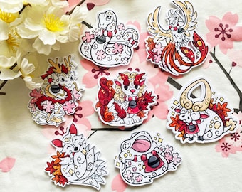 May include: Set of seven colorful stickers featuring various Japanese mythical creatures, including a dragon, a phoenix, a lion-dog, a bull, a frog, and two snakes. Each sticker has a white background with red, gold, and pink accents.