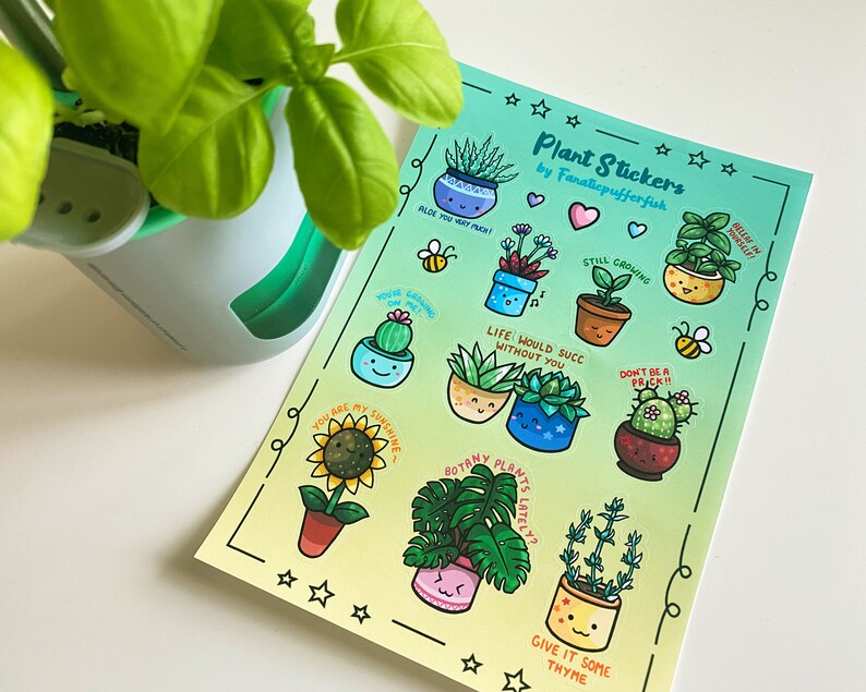 May include: A sheet of colorful plant stickers with cute illustrations and puns. The stickers feature various plants, including succulents, cacti, and a sunflower. The text on the stickers includes phrases like "Aloe You Very Much", "Still Growing", and "Life Would Suck Without You".