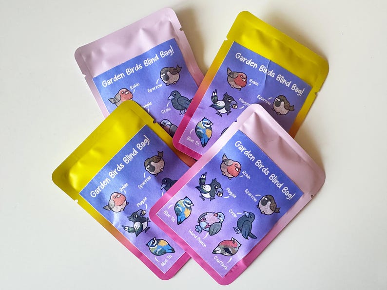 May include: Four pink and yellow pouches with the text "Garden Birds Blind Bag!" printed on them. Each pouch features a different set of illustrated birds with their names listed below.