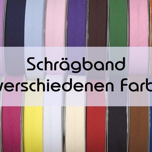Könnte beinhalten: Eine Reihe von Schrägband in verschiedenen Farben, auch bekannt als Einfassband. Der Text "Schrägband in verschiedenen Farben" ist im Bild sichtbar.
