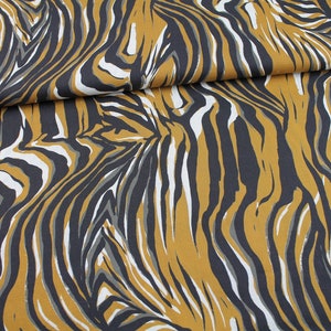 Pode incluir: Tecido com um padrão abstrato de listras de tigre em marrom, preto, branco e cinza.