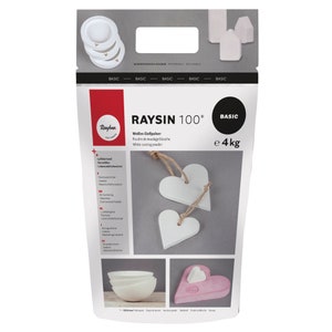 Könnte beinhalten: Ein weißer Beutel mit Rayher RAYSIN 100* weißem Gießpulver, einer Art Gips, zum Basteln. Der Beutel ist mit dem Produktnamen, dem Gewicht (4 kg) und Gebrauchsanweisungen versehen. Der Beutel zeigt auch Beispiele für Projekte, die mit dem Pulver hergestellt werden können, wie Herzen, Schalen und Häuser.