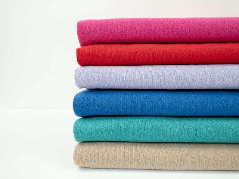 Puede incluir: Un conjunto de seis muestras de tela en varios colores, incluyendo rosa, rojo, lavanda, azul, verde azulado y beige.