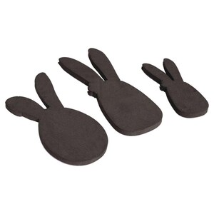 May include: Three black felt bunny shapes of varying sizes. The bunnies are cut out and have a simple design.