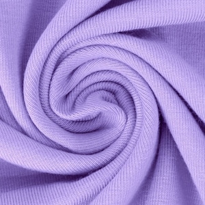 Könnte beinhalten: Nahaufnahme eines weichen, lilafarbenen Stoffes mit einem wirbelnden, strukturierten Muster. Der Stoff ist glatt und scheint aus Strickmaterial zu sein.
