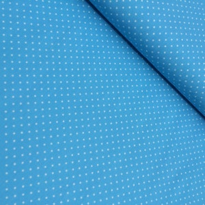 Könnte beinhalten: Ein Nahaufnahme eines hellblauen Stoffes mit einem weißen Tupfenmuster.