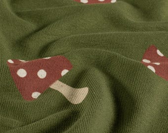 French Terry crepe paper with fly agaric mushrooms on fir greens – summer sweat fabric with tree bark texture