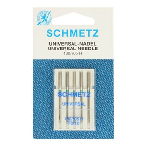 Könnte beinhalten: Eine Packung mit fünf silbernen Nähnadeln in einem durchsichtigen Kunststoffbehälter. Die Nadeln sind mit "SCHMETZ UNIVERSAL" und "130/705 H 70/10" beschriftet.