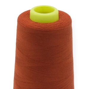 Könnte beinhalten: Eine Spule mit orangefarbenem Garn und einer gelben Kunststoffspule.