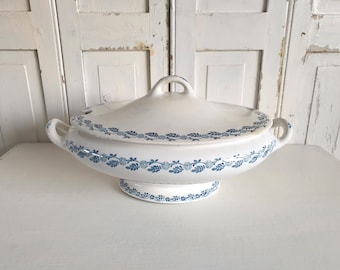 May include: White ceramic serving dish with a blue floral design. The dish has a lid and two handles.