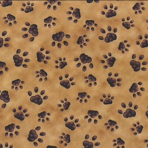 Op de afbeelding: Een bruine stof met een herhalend patroon van donkerbruine pootafdrukken.