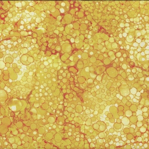 Op de afbeelding: Stof met een geel en oranje abstract patroon van overlappende cirkels en onregelmatige vormen. Een gele liniaal met zwarte markeringen staat rechts, met metingen in centimeters.