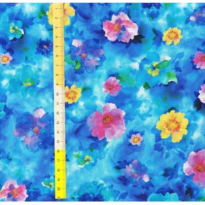 Könnte beinhalten: Ein blauer Stoff mit einem Aquarell-Blumenmuster mit rosa, gelben und blauen Blumen. Der Stoff hat eine weiche, fließende Textur.