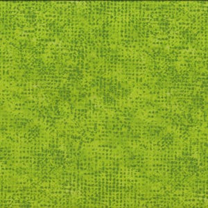 Op de afbeelding: Felgroene stof met een textuurpatroon van kleine, donkergroene vierkantjes. Een gele en witte liniaal is verticaal langs de rechterrand geplaatst en toont centimeter metingen. De stof heeft een gevlekt uiterlijk.