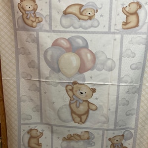Könnte beinhalten: Stoffpaneel mit einem sich wiederholenden Muster von Teddybären auf Wolken, Ballons und Sternen. Die Bären sind in verschiedenen Posen, einige mit Schleifen oder Hüten. Die Farbpalette umfasst Beige, Braun, Blau, Rosa und Grau.