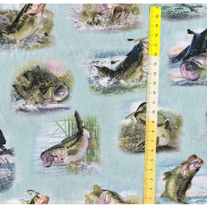 Może przedstawiać: Niebieski materiał z powtarzającym się wzorem skaczących z wody okoni. Ryby są zielone, brązowe i czarne z białymi oznaczeniami. Tło jest jasnoniebieskie.