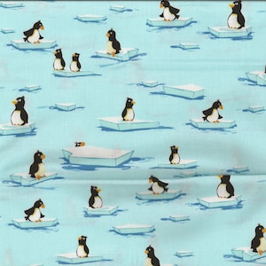 Könnte beinhalten: Hellblauer Stoff mit einem sich wiederholenden Muster von Cartoon-Pinguinen auf Eisschollen. Die Pinguine sind schwarz und weiß mit gelben Schnäbeln. Die Eisschollen sind weiß und blau.