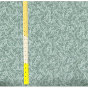 Op de afbeelding: Een turquoise stof met een herhalend patroon van kleine, donkergroene bladeren en bessen.