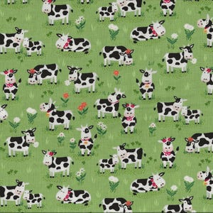 Könnte beinhalten: Ein grüner Stoff mit einem sich wiederholenden Muster aus schwarz-weißen Kühen. Die Kühe sind in verschiedenen Posen, darunter stehend, liegend und gehend. Einige Kühe haben ein kleines Kalb neben sich.