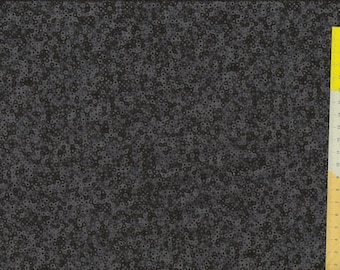 Può includere: Tessuto grigio scuro con un motivo ripetuto di piccoli cerchi irregolari. Un righello giallo con segni neri è posizionato lungo il bordo destro, che mostra le misure in centimetri. Il tessuto ha un aspetto strutturato.