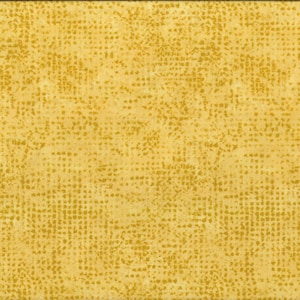 Könnte beinhalten: Senfgelber Stoff mit einem strukturierten, gepunkteten Muster. Ein gelbes und weißes Lineal ist vertikal am rechten Rand platziert und zeigt die Maße in Zentimetern an. Der Stoff hat ein gesprenkeltes Aussehen.