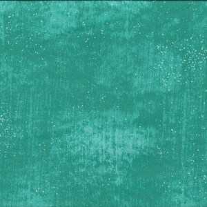 Peut inclure: Un tissu vert turquoise avec un motif blanc moucheté. Le tissu a une surface légèrement texturée.