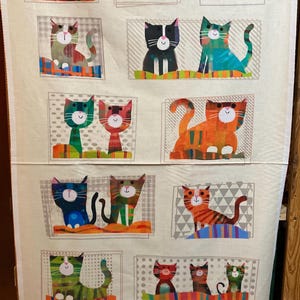 Può includere: Un pannello di tessuto con un motivo ripetuto di illustrazioni di gatti colorati e stilizzati. Ogni gatto è raffigurato in una posa e combinazione di colori uniche, su uno sfondo neutro con accenti geometrici. I gatti hanno uno stile stravagante e artistico.