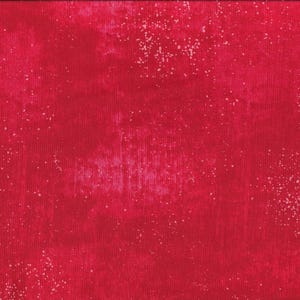 May include: Red fabric with a white speckled pattern. The fabric has a slightly textured surface.