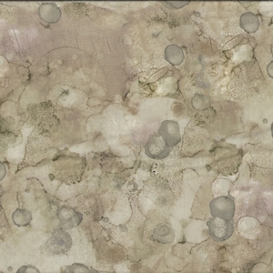 May include: A beige fabric with a mottled pattern of brown and gray spots. The fabric has a subtle texture and a slightly faded appearance.