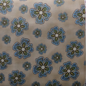 May include: Beige fabric with a repeating pattern of blue, green, and white stylized flowers.