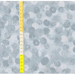 Peut inclure: Un tissu bleu clair avec un motif de pois blancs et gris. Le tissu est texturé et a un léger brillant.