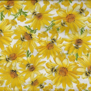 Könnte beinhalten: Ein weißer Stoff mit einem sich wiederholenden Muster aus gelben Gänseblümchen und Bienen. Der Stoff ist strukturiert und hat eine leicht glänzende Oberfläche.