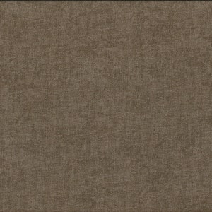 Può includere: Primo piano di un tessuto marrone con una superficie testurizzata. Un metro a nastro giallo è visibile sul lato destro dell'immagine.