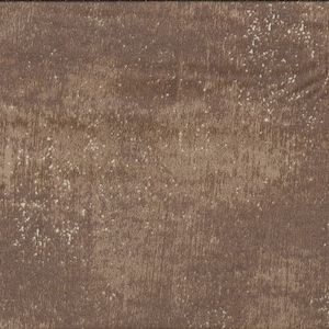 Op de afbeelding: Bruine stof met een getextureerde, verweerde uitstraling. De stof heeft een houtachtige nerf met lichtere, gespikkelde accenten. Een gele liniaal met zwarte markeringen staat aan de rechterkant, met metingen in centimeters.