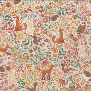 Op de afbeelding: Een stofpatroon met een grillige bosscène. Het ontwerp bevat vossen, uilen, eekhoorns en egels te midden van kleurrijke bloemen en bladeren in tinten oranje, geel en groen. De achtergrond is zacht wit.