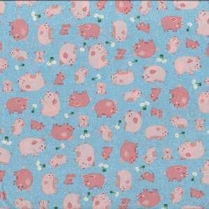 Può includere: Un tessuto blu con un motivo ripetitivo di maiali rosa. I maiali sono in varie pose, alcuni sono in piedi, altri sono sdraiati e altri guardano di lato. Il tessuto è perfetto per il quilting, la cucitura e l'artigianato.