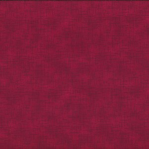 May include: A deep red fabric with a textured pattern of dark intersecting lines. A yellow ruler with black markings is visible along the right edge, showing measurements in centimetres.