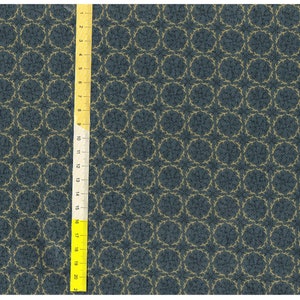May include: A blue fabric with a repeating pattern of gold circles with a delicate, leafy design. The fabric is textured and has a subtle sheen.