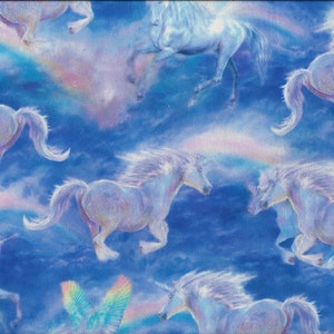 Puede incluir: Una tela azul con un patrón repetido de unicornios blancos galopando a través de un cielo nublado con acentos de arcoíris.