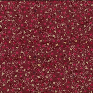 Puede incluir: Tela burdeos con un patrón repetido de corazones rojos, rosas y dorados. Los corazones varían en tamaño y estilo. Una regla amarilla es visible, mostrando medidas en centímetros.