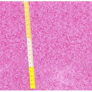 May include: A close-up of a pink fabric with a speckled pattern. A yellow measuring tape is visible on the right side of the image.