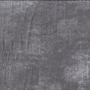 Op de afbeelding: Een close-up van een donkergrijze stof met een subtiel gespikkeld patroon. De stof heeft een textuur, een licht ruw oppervlak.