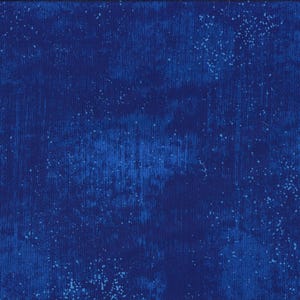 Op de afbeelding: Een blauwe stof met een gespikkeld wit patroon. De stof heeft een textuur en een verweerde uitstraling.