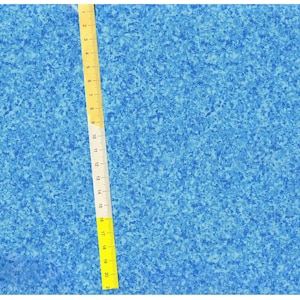 May include: A close-up of a blue fabric with a speckled pattern. A yellow measuring tape is visible on the right side of the image.