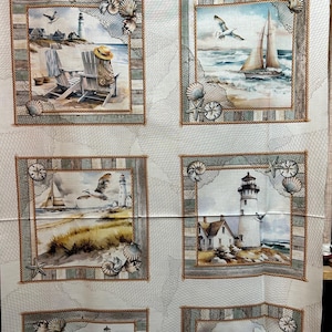 Peut inclure: Un panneau de tissu avec six scènes côtières encadrées. Chaque scène représente un phare, des voiliers ou des chaises de plage, sur le thème nautique. Les cadres sont décorés de cordes, de coquillages et de filets, avec une bordure bleue et blanche.