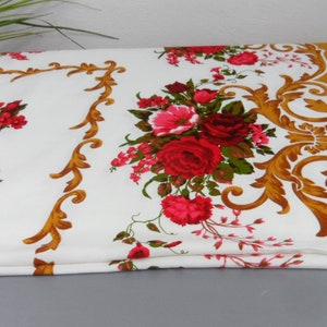 Op de afbeelding: Witte tafelkleed met een gouden en rood bloemenpatroon. Het tafelkleed heeft een gouden rand met een bloemenontwerp en een effen gouden gedeelte aan de onderkant.