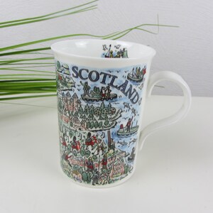 May include: White ceramic mug featuring a colourful illustration of a map of Scotland. The mug has a handle and the word "Scotland" is printed on the side.