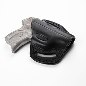 May include: A black leather holster with a stitched design. The holster is designed to hold a handgun. The image is set against a white background.